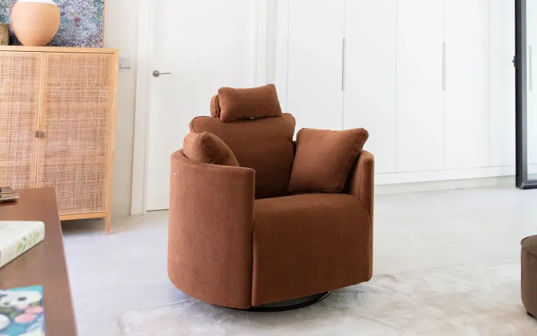 Fauteuil relax Moonrise de Fama Sofás, tapissé en tissu marron, avec appui-tête réglable et design enveloppant aux lignes arrondies.