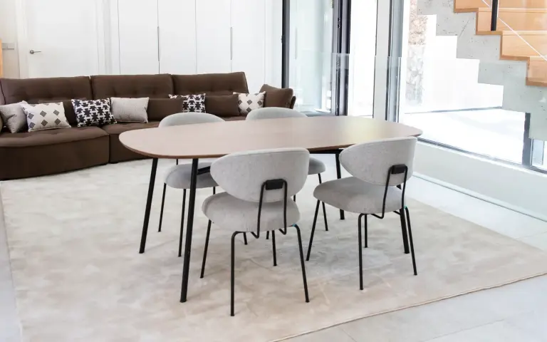 Nereida-Stühle von Fama mit weicher grauer Polsterung und schwarzem Metallgestell um einen Holztisch, mit elegantem und funktionalem Design