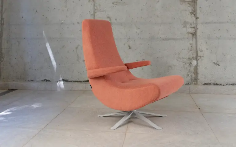 Fauteuil pivotant Swing, revêtu en rose corail, au joli design et doté d’une base en métal.