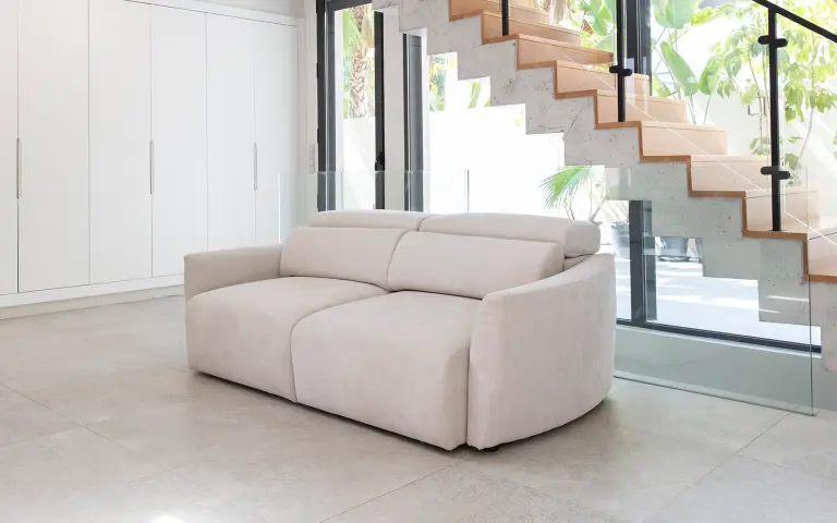Canapé compact tapissé avec le tissu Astral, un textile polyvalent et confortable dans une teinte neutre pour des espaces contemporains.